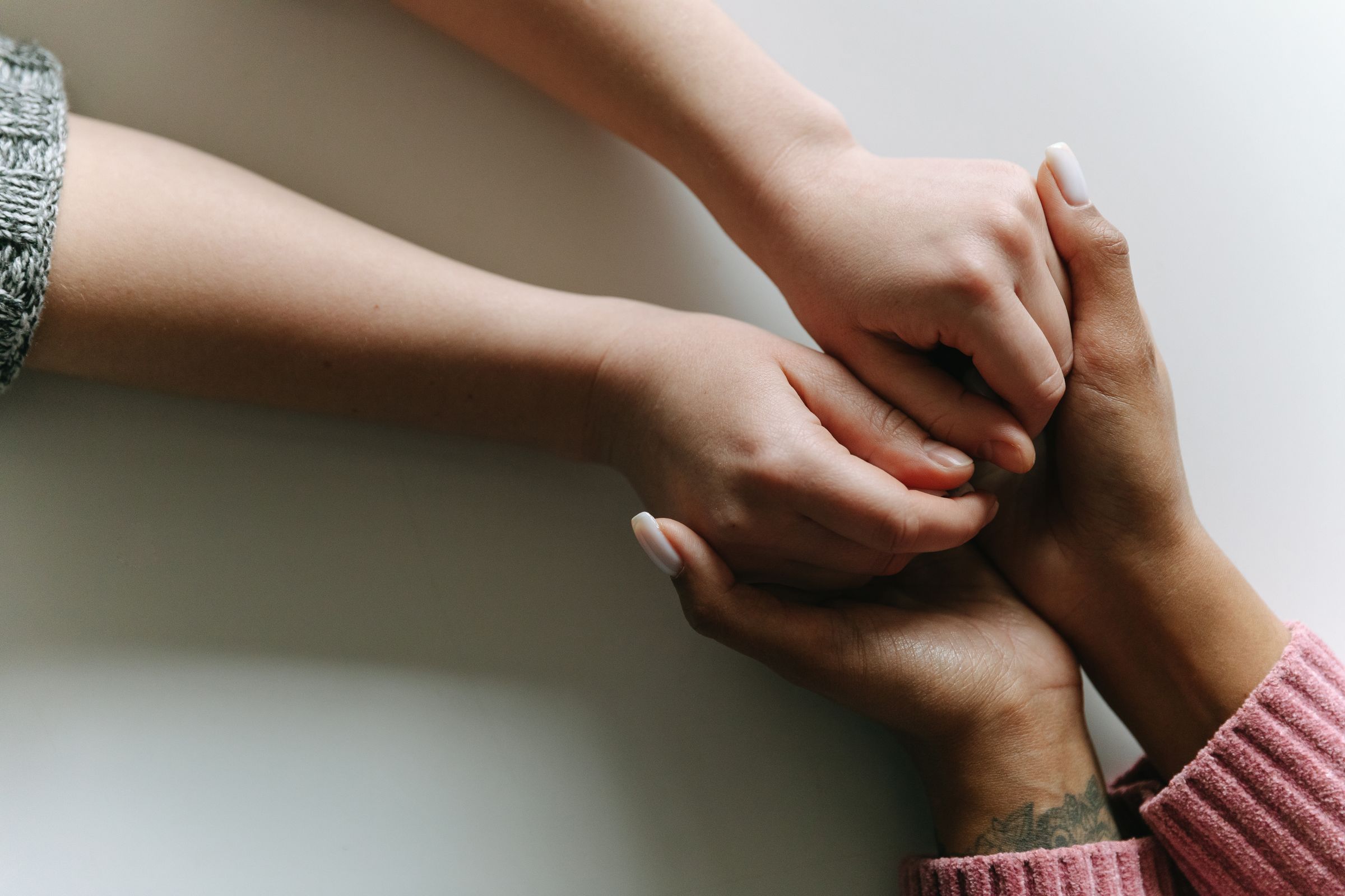Two people holding hands in a gesture of care and support
