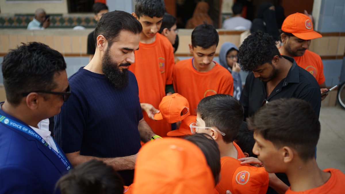 A volunteer handing supplies to children during an outreach